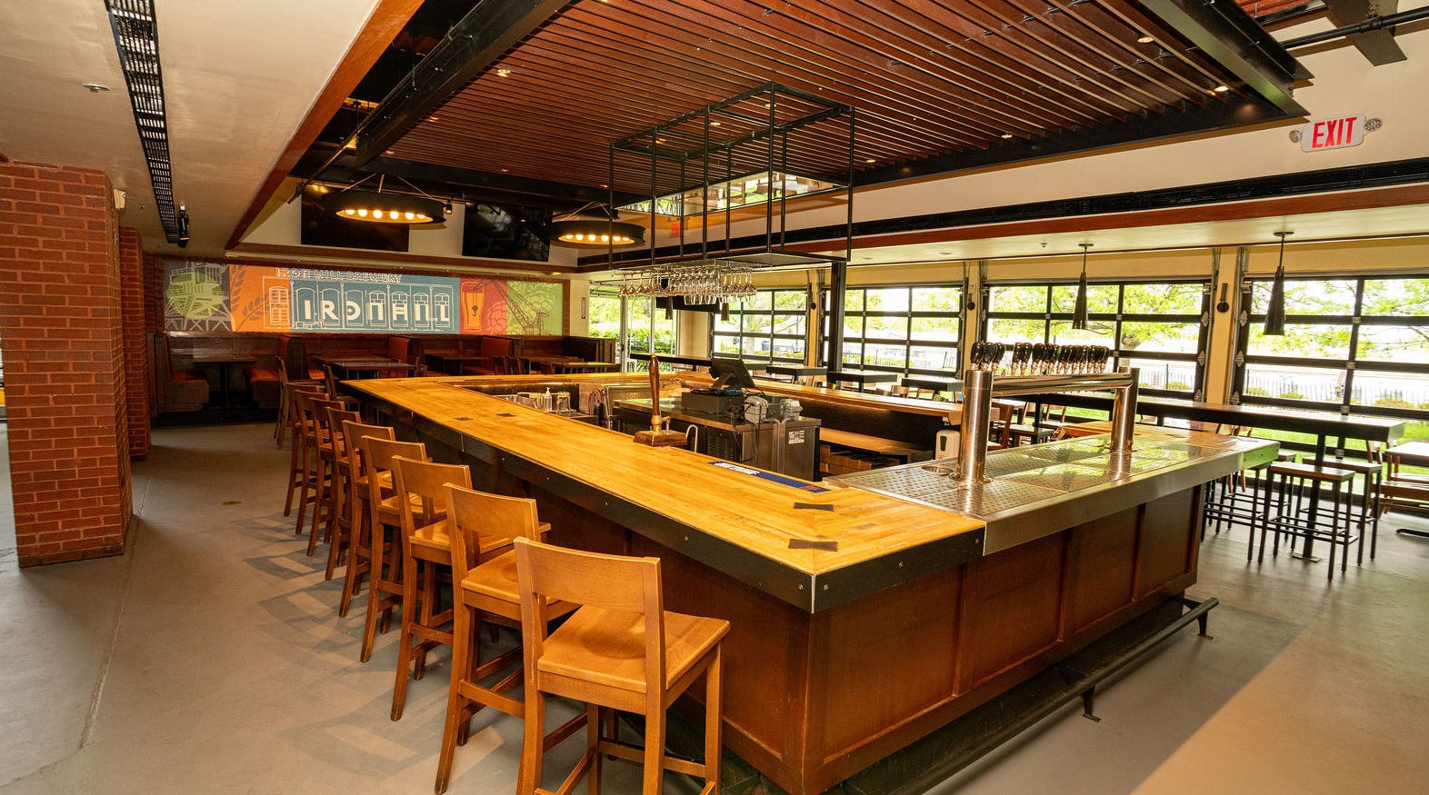 Iron Hill Brewery branded glass filled with golden craft beer, surrounded by fresh hops
